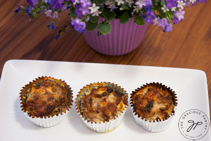 A platter of these Spinach And Feta Breakfast Muffins sits next to a potted plant on the table.