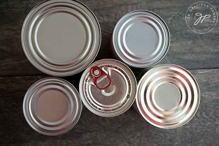 An overhead view of the tops of five cans in this collection of recipes for a can of whatever is in your cupboard or pantry.