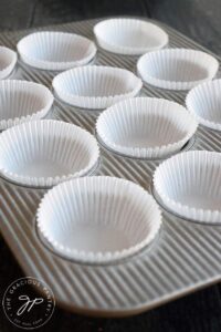 A muffin pan lined with cupcake papers, ready to make these Gluten Free Lemon Poppy Seed Muffins.