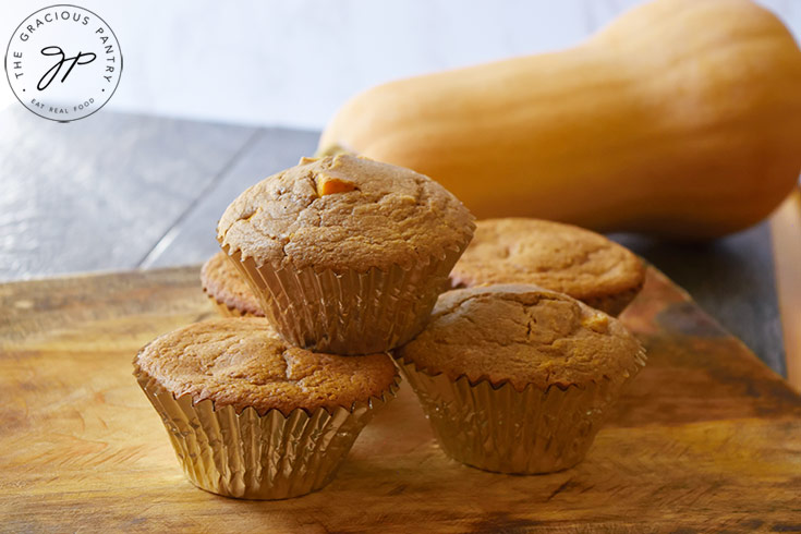 A side view of a stack of Butternut Squash Muffins on a cutting board.