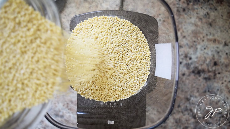 Millet being poured into a grinder.