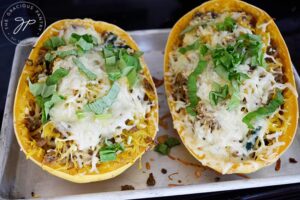Two just-baked Italian Spaghetti Squash Boats sitting on a baking pan.