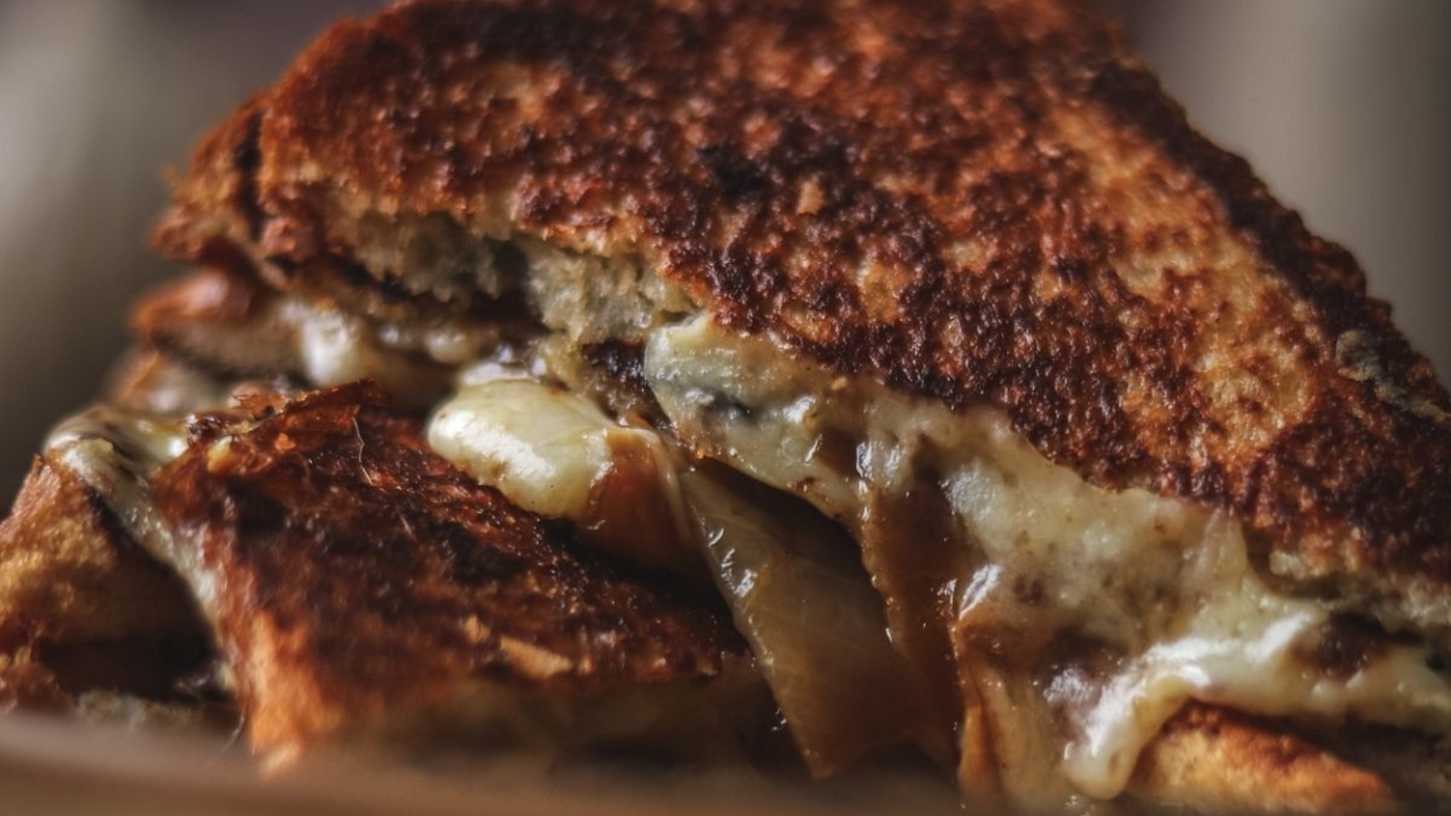 A closeup of a caramelized grilled onion grilled cheese sandwich.