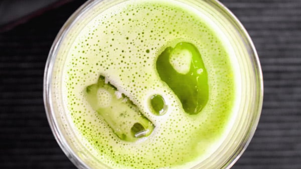 An overhead shot of a glass filled with matcha tea and ice.