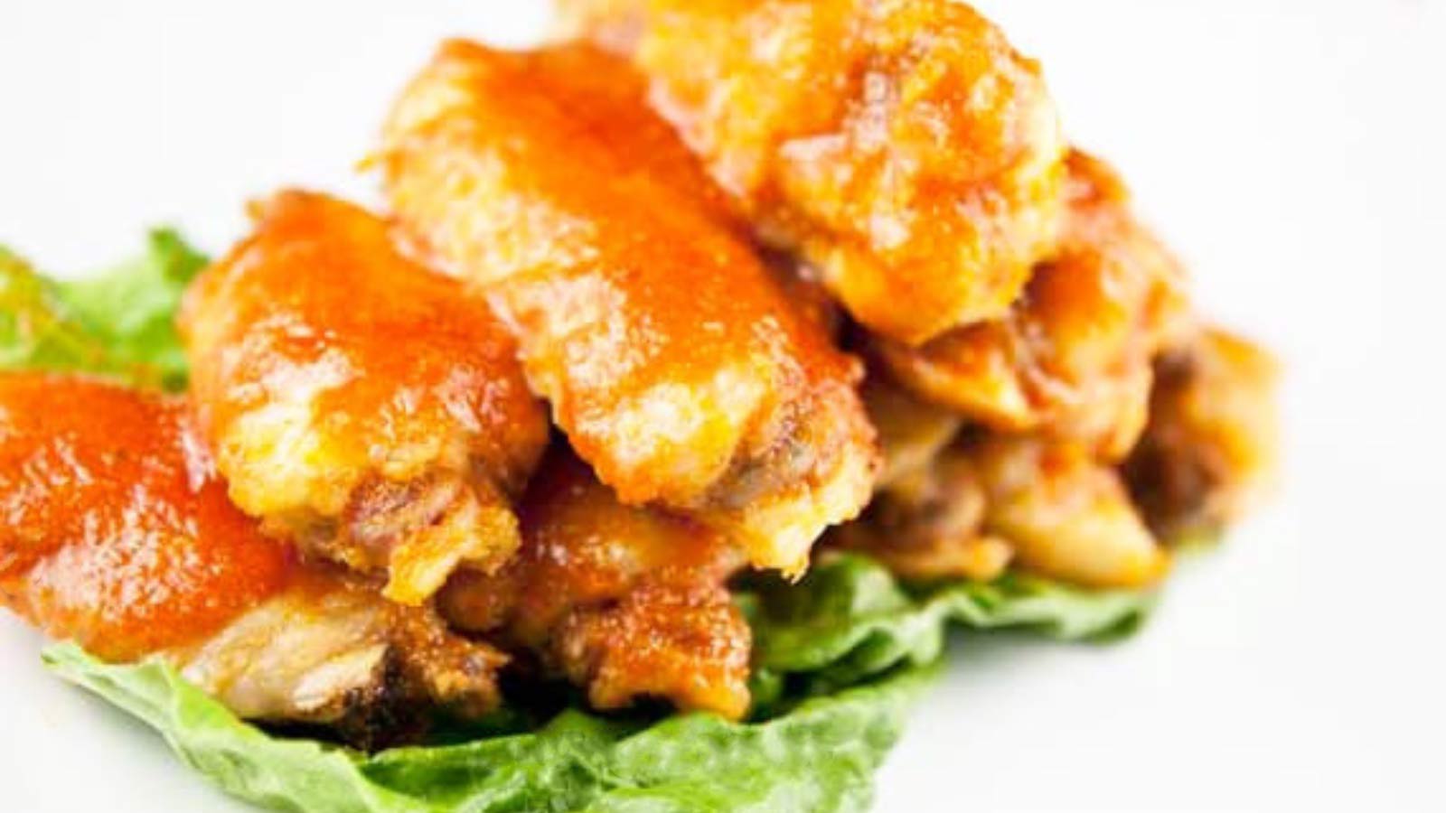 A stack of buffalo wings resting on lettuce.