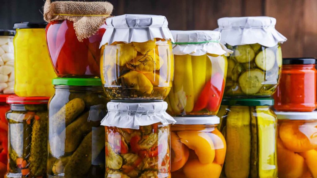 Jars with variety of marinated vegetables and fruits. Preserved food.