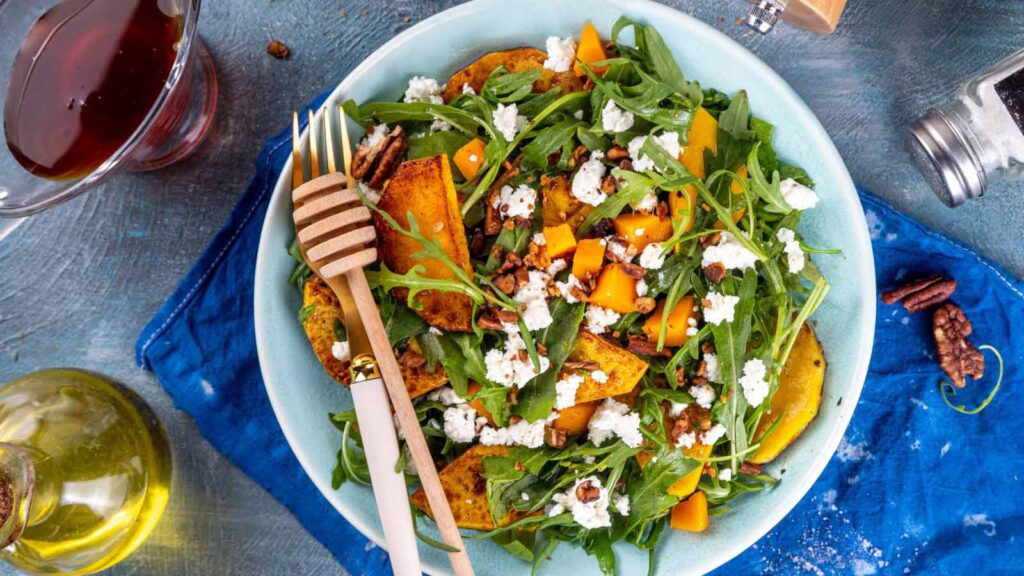 A salad with feta and roasted butternut squash, perfect for drizzling maple dressing over.