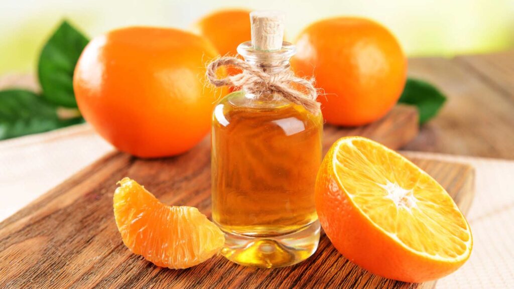 Tangerine oil on table on light background.