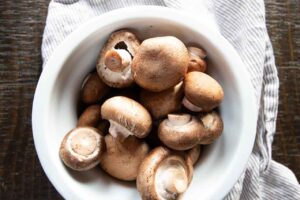 Raw mushrooms in a white bowl.