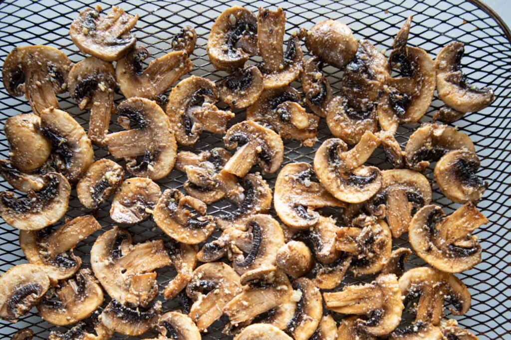 Raw mushrooms with seasoning sauce on them in a basket.