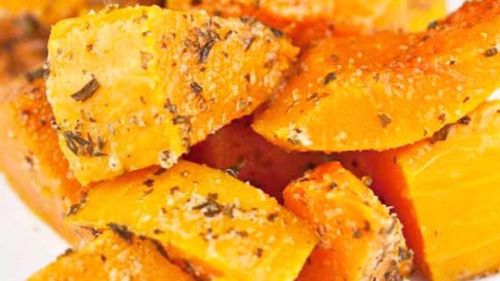 Herb Baked Butternut Squash in a pile on a white plate.