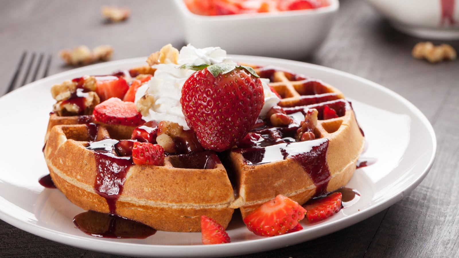 Belgium waffle topped with boysenberry syrup, whipped cream, walnuts, and freshly chopped strawberries.
