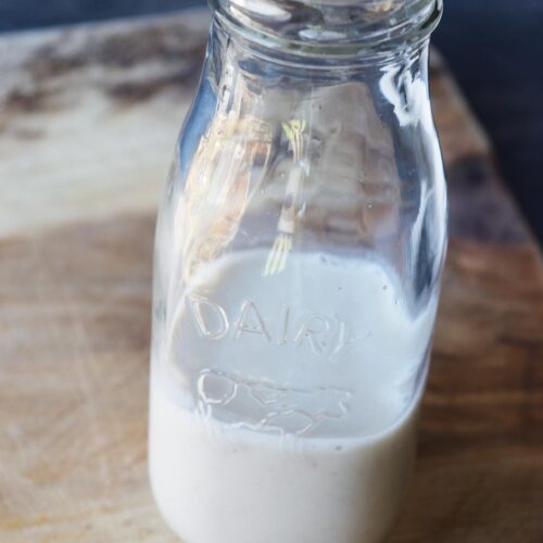 A side view of a glass jar filled with Condensed Milk.