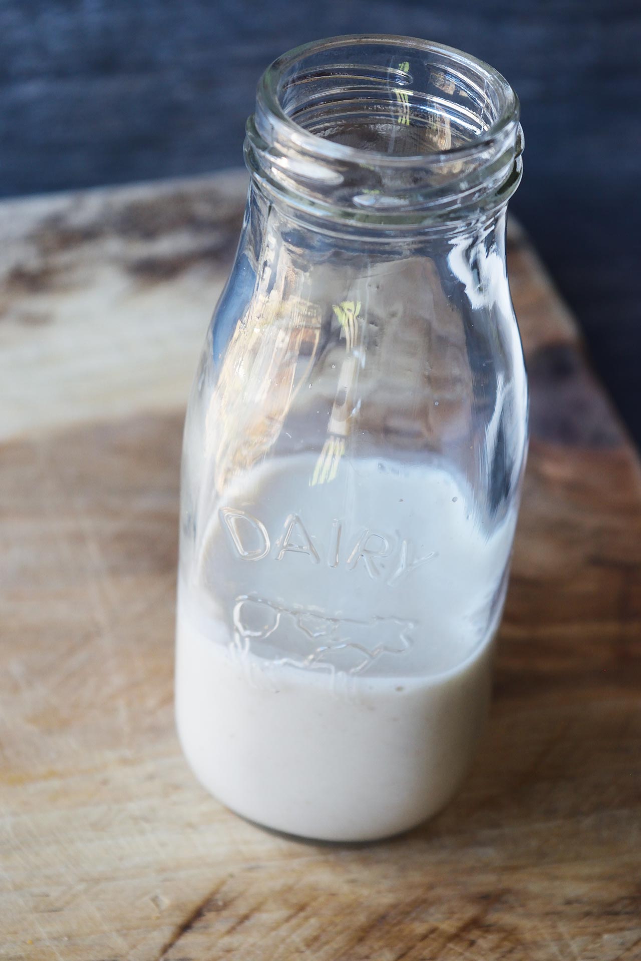 A side view of a glass jar filled with Condensed Milk.