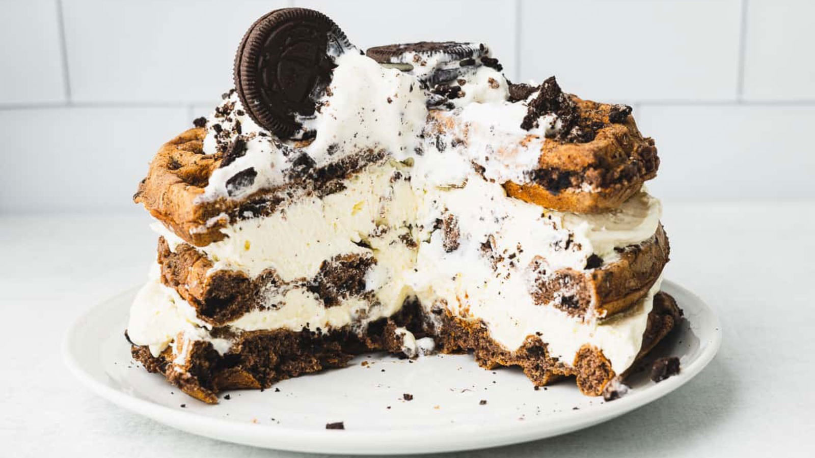 A stack of Oreo waffled with shipped cream between them.