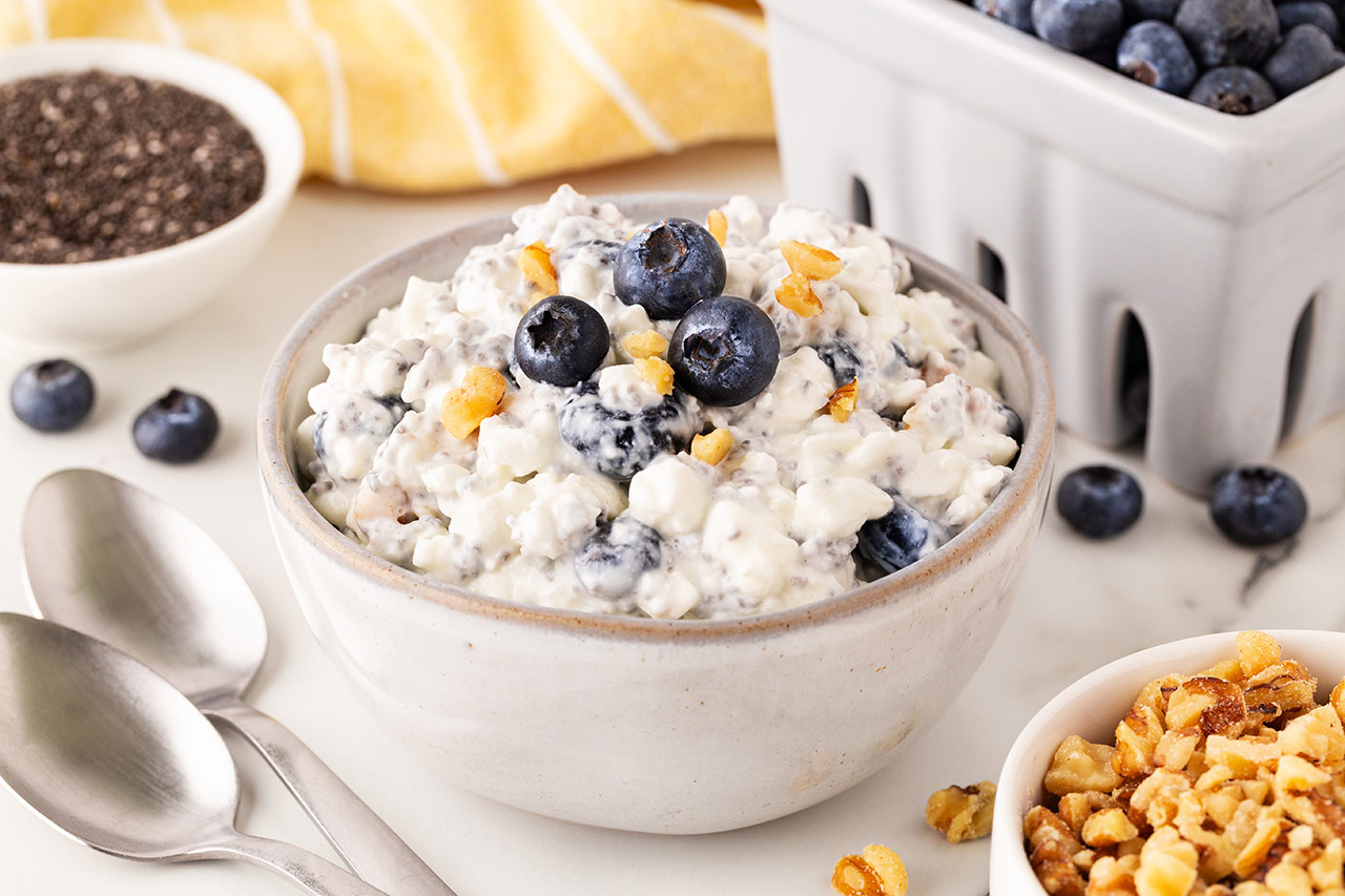 Blueberry Cottage Cheese in a white bowl sitting on a table.