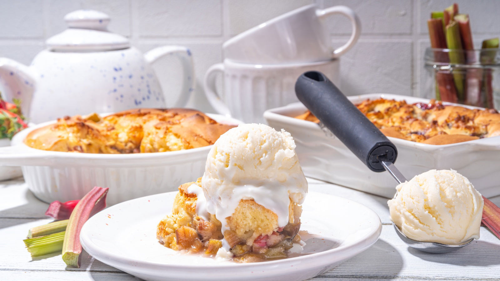 Sweet carrot cake cobbler served with vanilla ice cream ball, on sunny white wooden kitchen table.