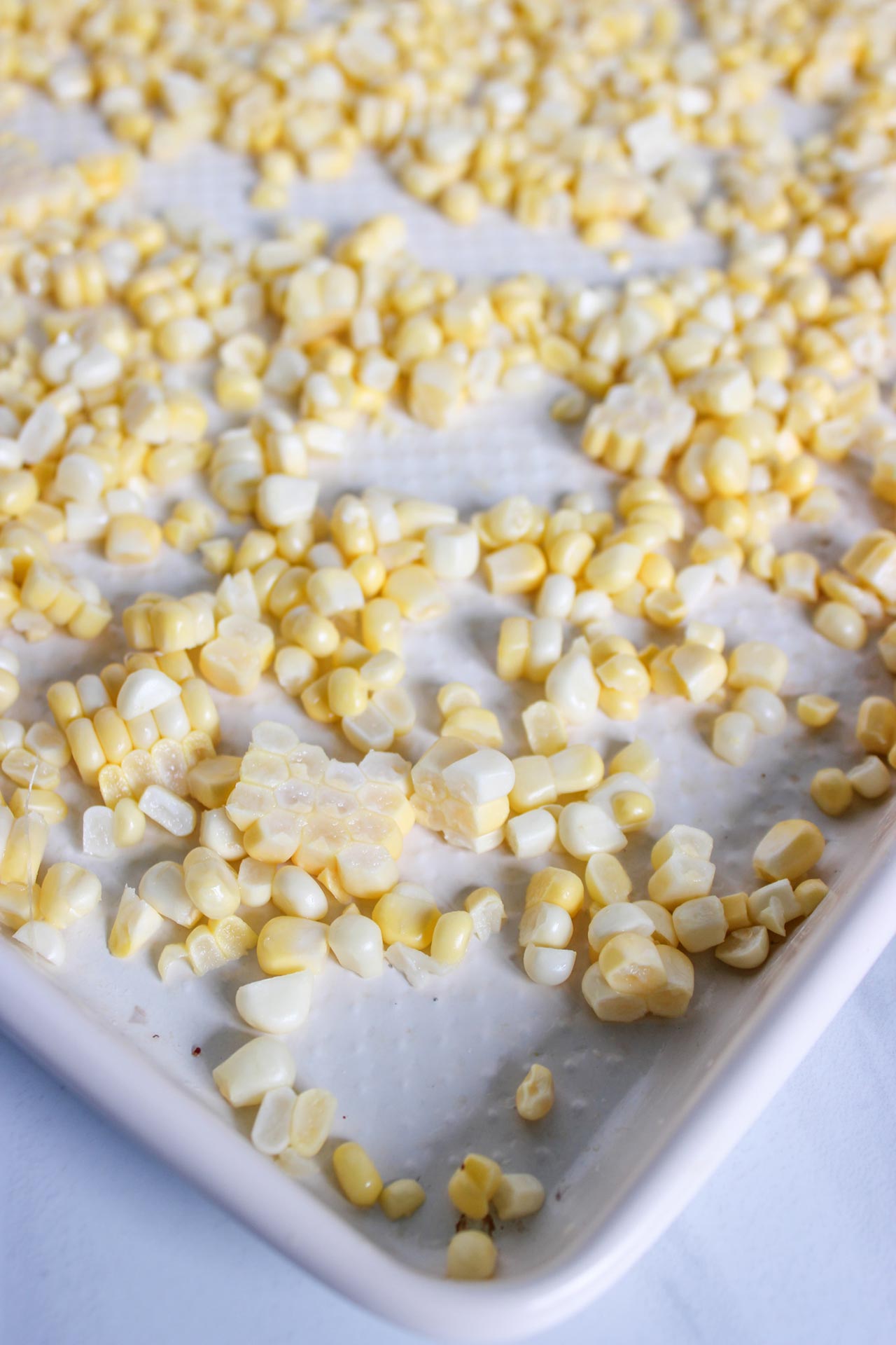 Raw corn kernels on a sheet pan.