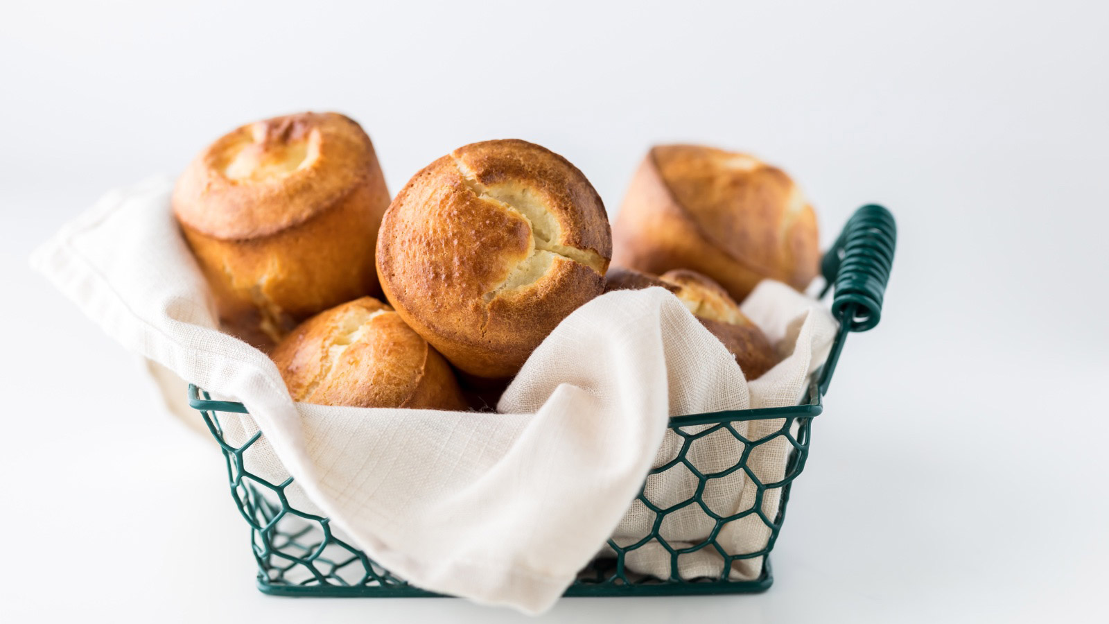 Close up of a basket of freshly baked popovers ready for sharing.