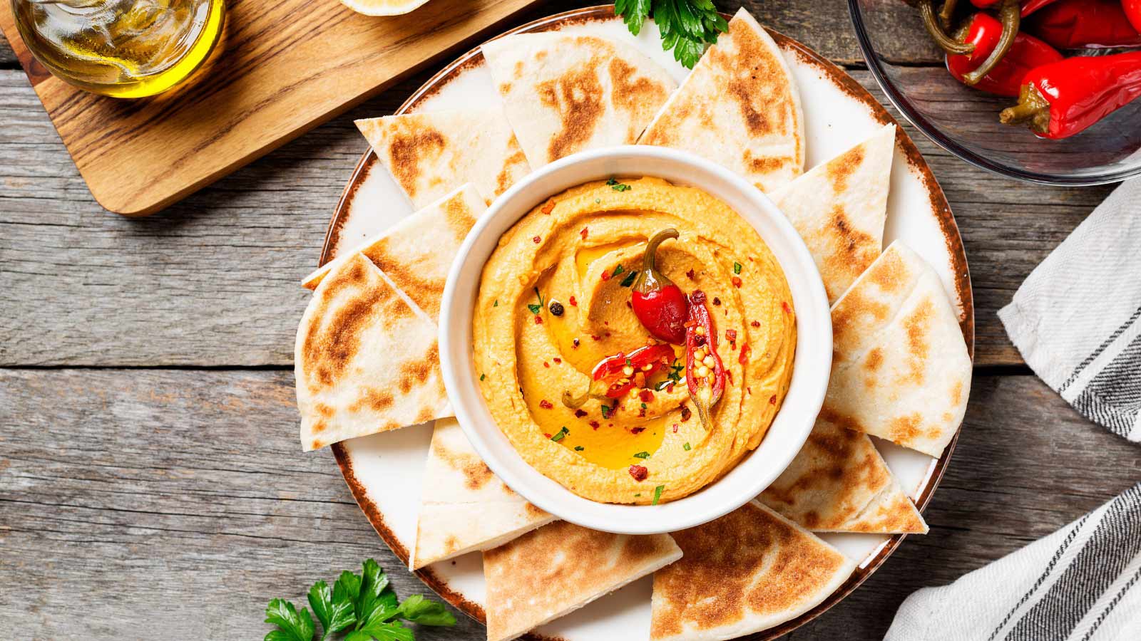 Taco hummus with pita bread on wooden background. top view