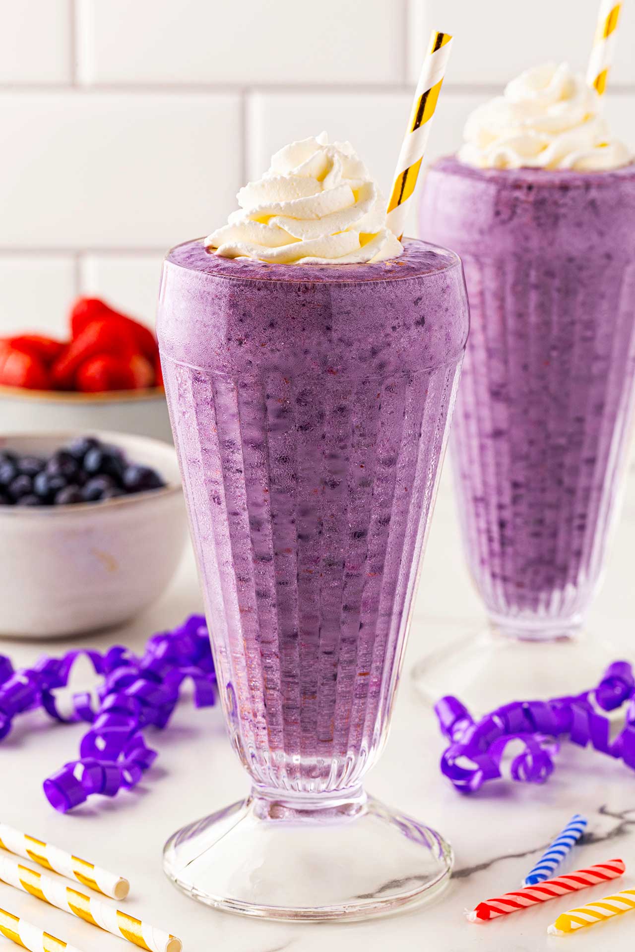 Two glasses on a countertop filled with Grimace Shake.
