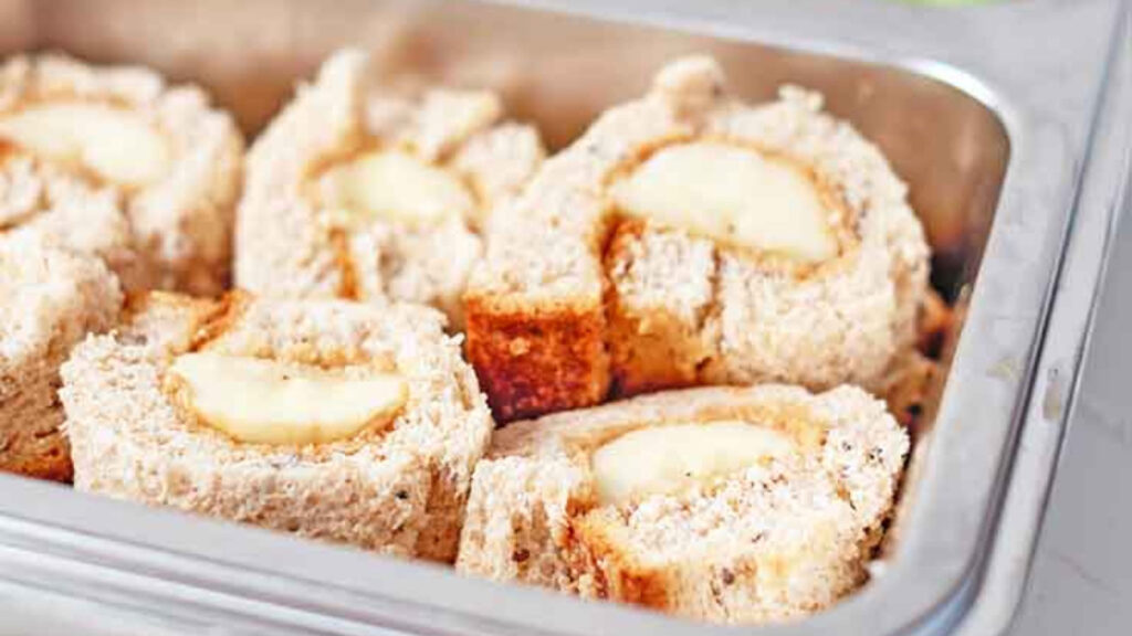 A closeup of banana sushi slices in a bento tin.