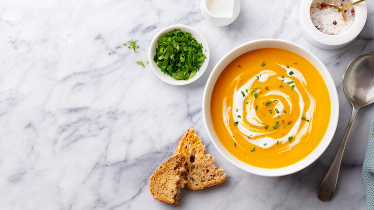 Pumpkin traditional soup with creamy silky texture. Marble background. Copy space. Top view.